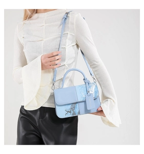 Détail du sac bandoulière bleu clair avec empiècement serpent et bandoulière réglable