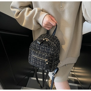 Détail de la texture en tweed et du zip doré sur ce mini sac à dos noir pour femmes