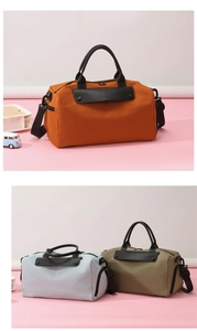 Detail of large travel duffel bag with leather trim handles and adjustable shoulder strap
