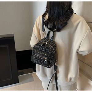 Vue arrière d'un mannequin portant le mini sac à dos en tweed noir et blanc avec doré
