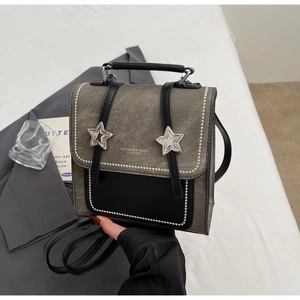 Détail du mini sac à dos rétro avec boucles étoiles et tissu gris texturé