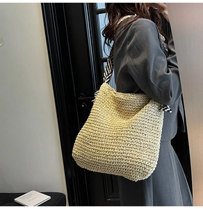 Détail du sac cabas en paille tissée avec une bandoulière rayée noire et blanche élégante