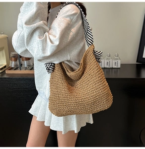 Détail du sac hobo en paille tressé avec bandoulière textile à rayures noires et blanches