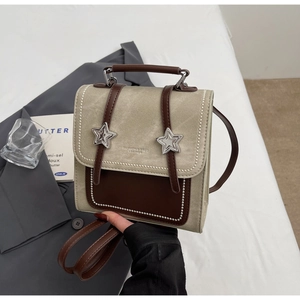 Détails d'un sac à dos rétro avec boucles étoiles et coutures perlées blanches