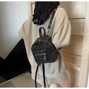 Vue détaillée d'un mini sac à dos en tweed avec tissage noir et or et nœud en cuir