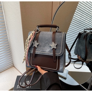 Détail du sac à dos en jean et cuir avec étoiles et breloque en corde tressée