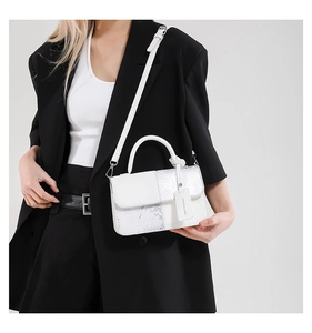 Détail de la texture serpent et du cuir blanc sur un petit sac carré à bandoulière