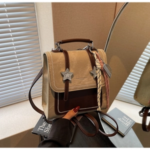 Détail du sac à dos rétro beige et marron avec étoiles en métal et breloque en foulard
