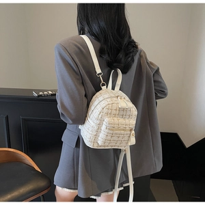 Détail du mini sac à dos en tweed montrant la texture tissée et les zips dorés