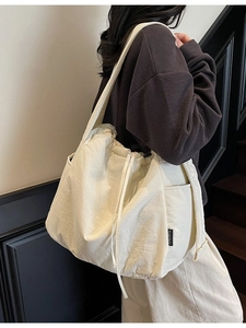 Minimalist cream canvas shoulder bag with drawstring closure and large capacity storage