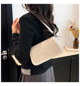 Detail of cream woven shoulder bag with FASHION & BAGS text and silver metal buckle