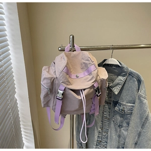 Detail showing lavender waterproof nylon fabric texture and metal buckle of the backpack