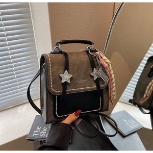 Macro shot of retro two-tone handbag with silver star studs and woven pendant details