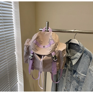 Close-up of light purple nylon backpack showing metal buckle and drawstring closure