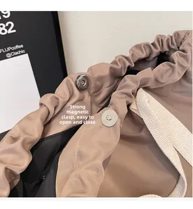 Detail of strong magnetic snap closure and drawstring on nylon bucket tote bag