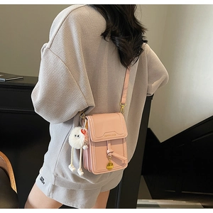 Pink glossy PU leather crossbody bag with cute plush ball and golden charm detail