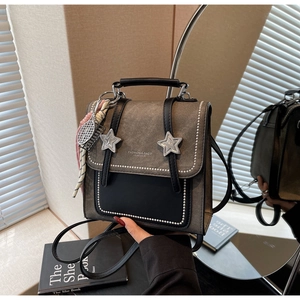 Détail du petit sac à dos rétro en nubuck gris avec boucles étoiles et pendentif
