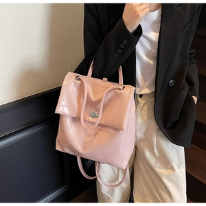 Detalle de textura de cuero de cocodrilo rosa y cierre giratorio plateado en la mochila
