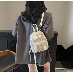 Détail d'un sac à dos élégant en tweed crème avec fils dorés et fines bretelles
