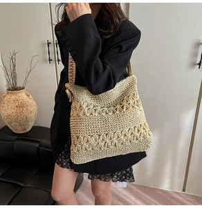 Détail du cabas en paille tissée avec bandoulière brodée bohème et motif au crochet ajouré