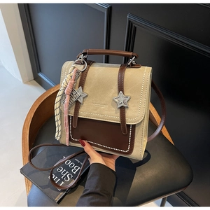 Détail d'un sac à dos vintage en toile et cuir avec boucles étoiles et pompon frangé