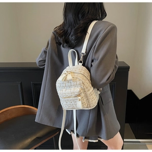 Détail d'un mini sac à dos en tweed sur modèle avec texture tissée et finitions dorées