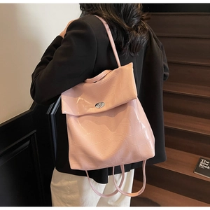 Detalle de la mochila rosa claro con textura de cocodrilo y cierre giratorio plateado