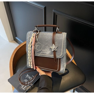 Détail d'un sac à dos en denim bleu avec bordure en cuir marron et accents d'étoile