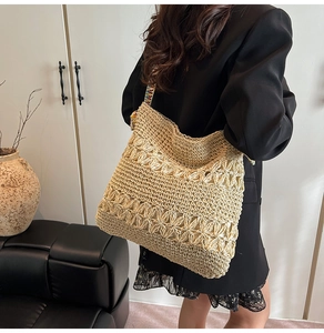 Détail du sac cabas en paille tissé avec motif floral ajouré et bandoulière colorée
