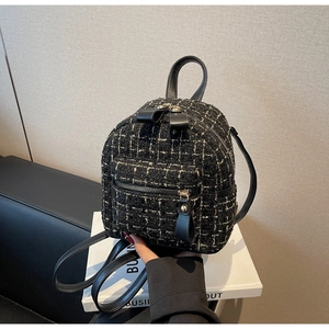 Détail d'un mini sac à dos élégant en tweed noir et blanc avec finitions dorées et cuir