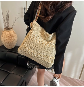 Gros plan détaillé du sac cabas en paille avec tissage floral et sangle jacquard