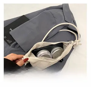 Internal view of the cream leather crossbody bag showing storage space for phone and makeup
