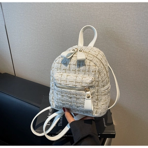 Gros plan sur un mini sac à dos en tweed blanc avec fils dorés et finitions en cuir PU