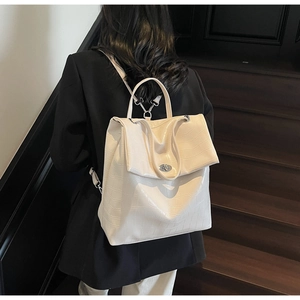 Detalle de la mochila de ecocuero crema con relieve de cocodrilo y cierre de giro plateado