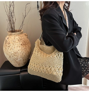 Détail du sac cabas en paille tressée avec motifs floraux et bandoulière colorée