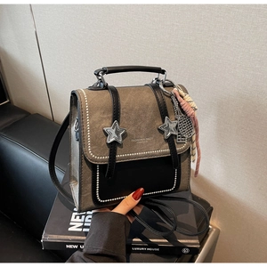 Detail of vintage gray textured mini backpack with decorative charms and leather straps
