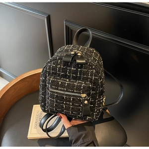 Détail d'un mini sac à dos en tweed à carreaux avec des accents de fils d'or élégants