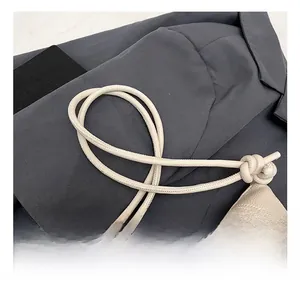 Detail of off-white lychee texture leather bag with cord handle and chick charm