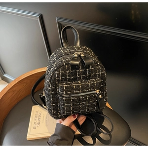 Gros plan d'un mini sac à dos en tweed avec détails dorés sur une chaise