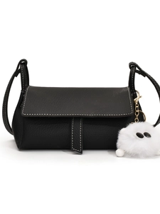 Black pebbled crossbody bag with white contrast stitching and cute plush ball charm