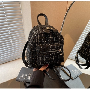 Détail d'un mini sac à dos en tweed avec nœud noir et fermeture éclair dorée