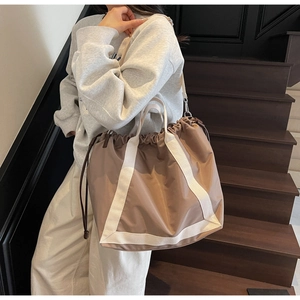 Close-up of lightweight nylon tote bag with drawstring closure and contrasting straps