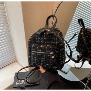 Détail du mini sac à dos en tweed noir à carreaux avec nœud en cuir et zip doré