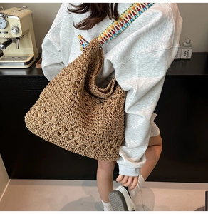 Détail du sac cabas en paille tissé main avec motif fleuri ajouré et bandoulière colorée