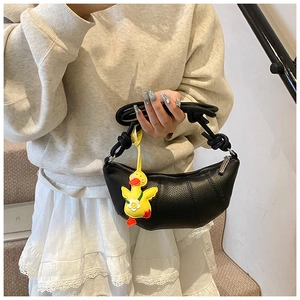 Detail of black crescent moon bag with lychee texture and a yellow duck charm