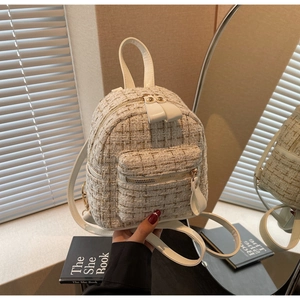 Détail du mini sac à dos en tweed avec fils dorés et finitions métalliques dorées