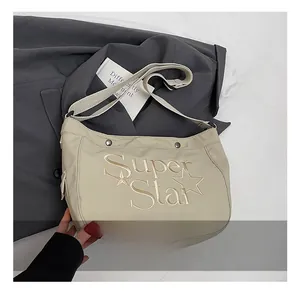 Détail du sac cabas en toile avec broderie Super Star et large bandoulière en coton