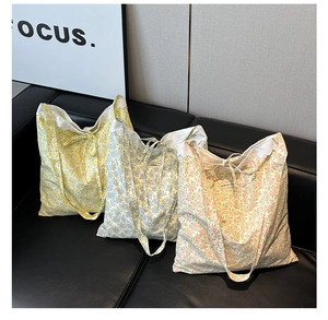 Détail de sacs fourre-tout à fleurs avec bordure en dentelle et rubans de diverses couleurs