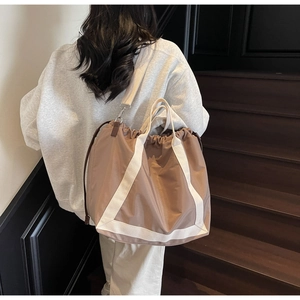 Detail of casual nylon tote bag with drawstring closure and white webbing accents
