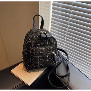 Détail d'un mini sac à dos en tweed à carreaux avec poignée en cuir et poche zippée